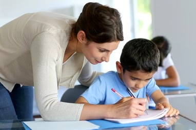 Teacher helping young boy with writing lesson-1